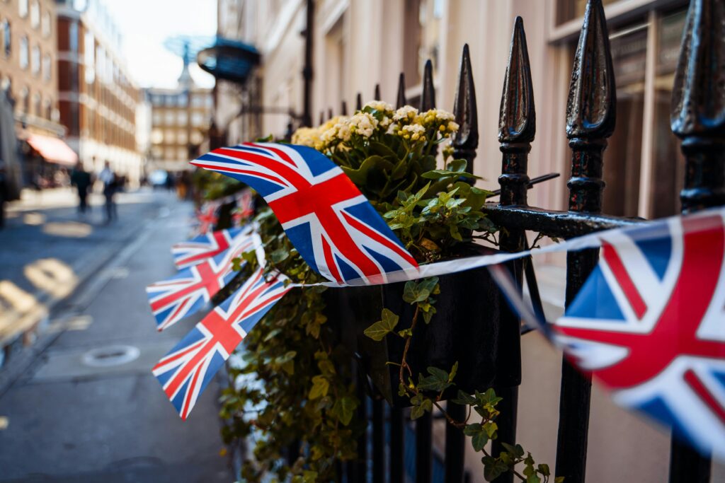 pexels-photo-29740446-29740446 Close-up of Union Jack flags decorating a London street on a sunny day.